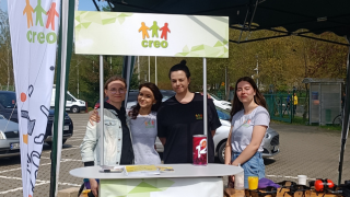 Grupa kobiet na tle stoiska CREO. Uśmiechają się do kamery