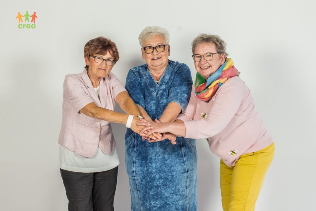 Grupa uśmiechniętych seniorów.