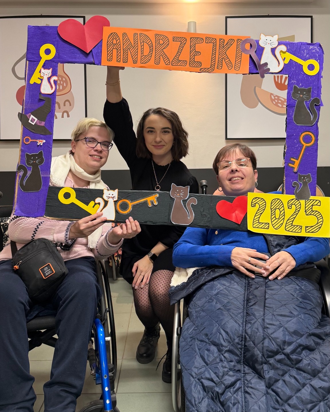 Zdjęcie przedstawia trzy kobiety trzymające ramkę do zdjęć